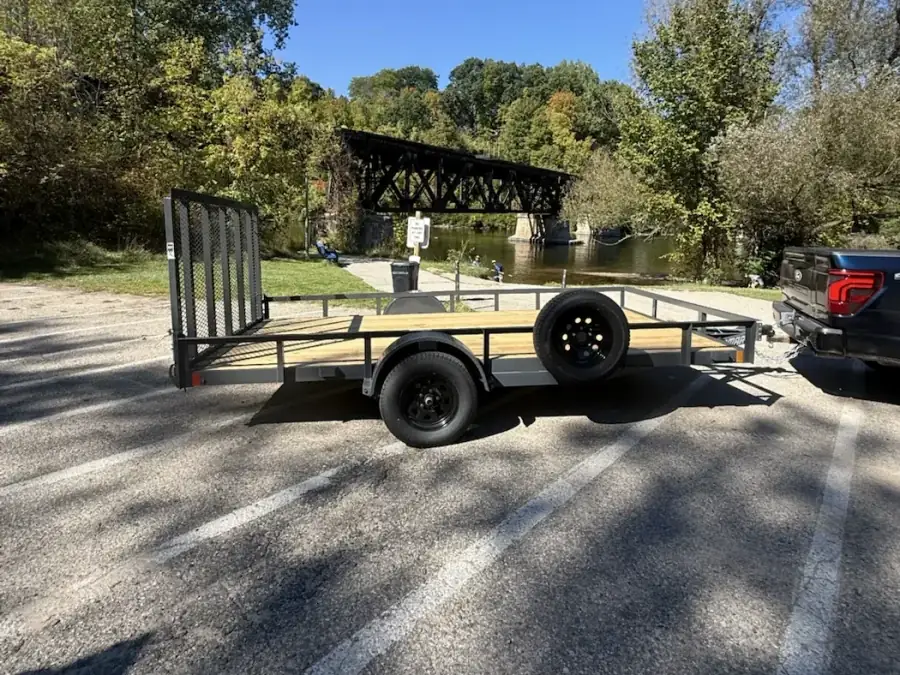 JH Trailer Rental’s 2027 Lamar 83×14 utility trailer parked near the Muskegon River in Newaygo, Michigan